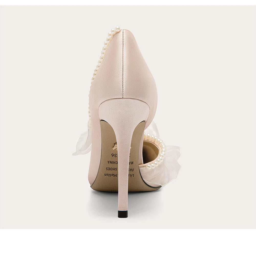 Beige high-heeled shoes with pearl details on a white background