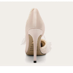 Beige high-heeled shoes with pearl details on a white background