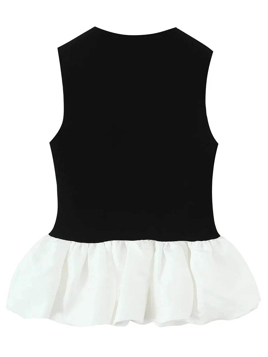 Black top with white ruffled hem on a white background