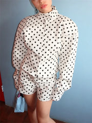 Person wearing a polka dot outfit with a plain background