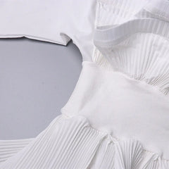 Close-up of a white pleated garment on a light gray background