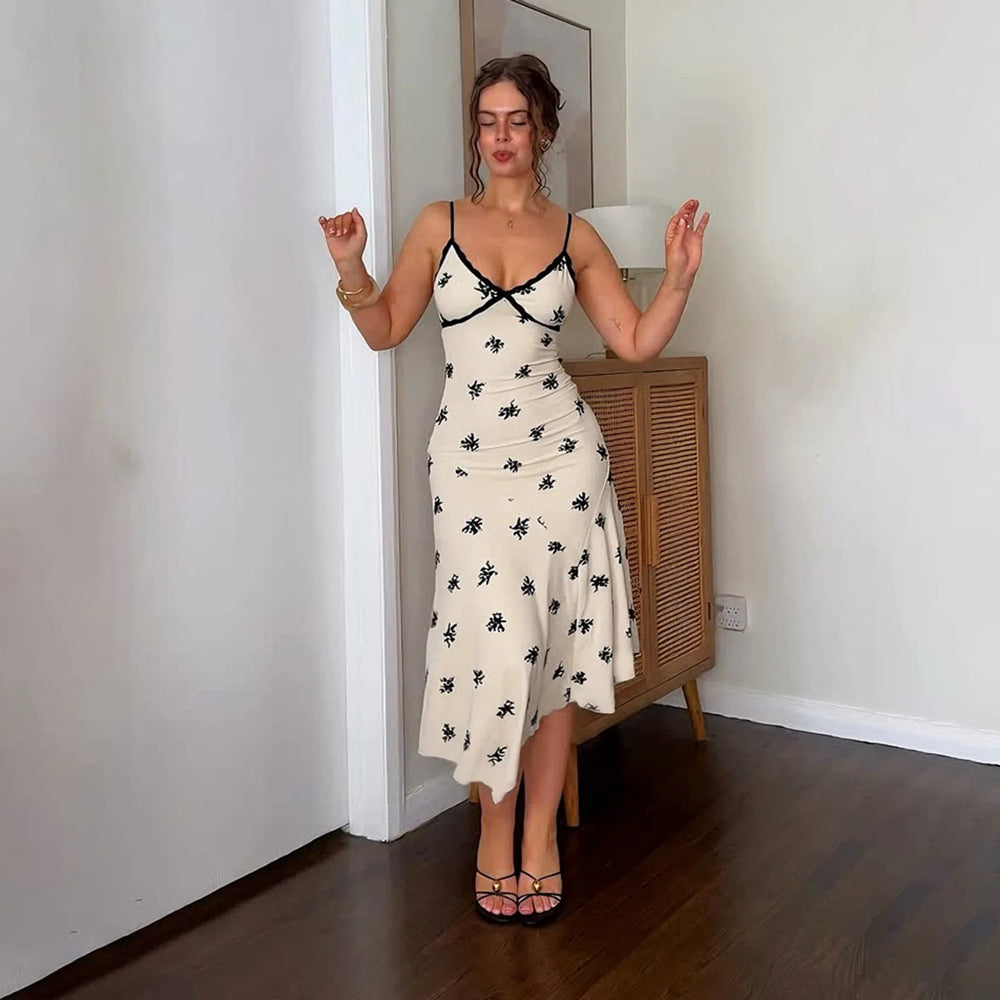Woman wearing a white dress with black floral patterns in a room.