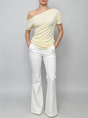 Person standing wearing a diagonal collar asymmetrical top