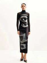 Model wearing a black dress with eye designs on a white background