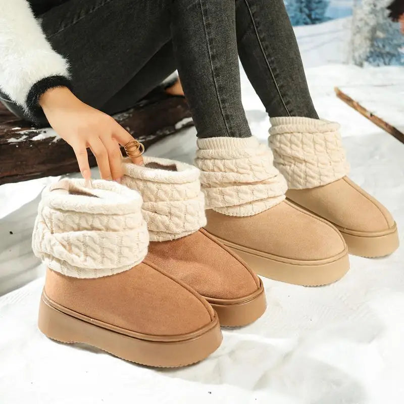 Tan winter boots with white textured trim worn by a person sitting on a snowy surface.