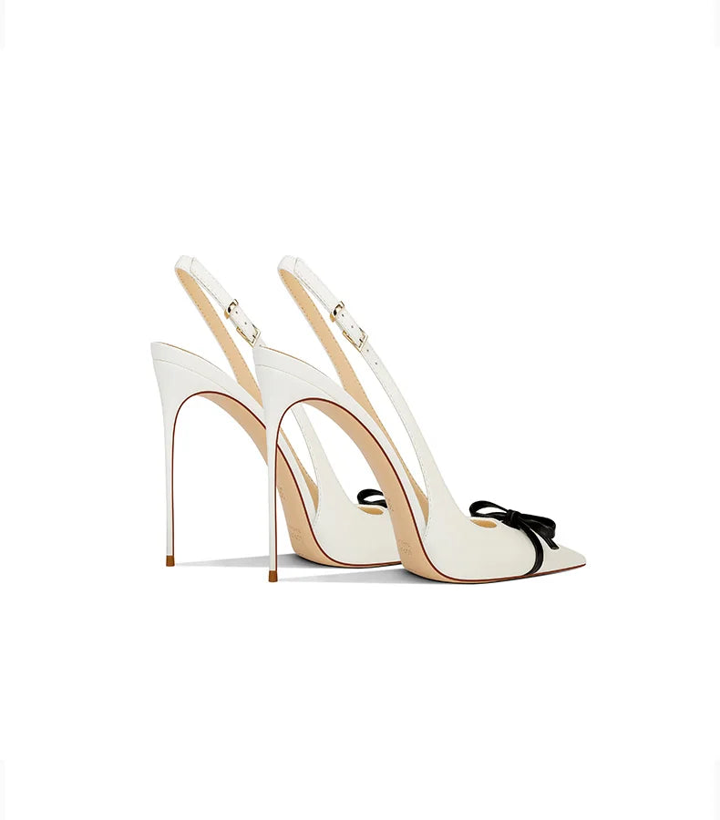 White high-heeled shoes with a bow on a white background