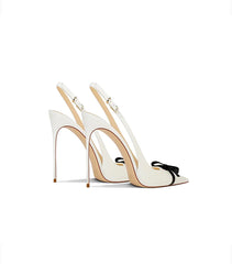 White high-heeled shoes with a bow on a white background