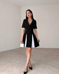 Woman wearing a black and white dress in an indoor setting