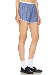 Person wearing blue and white checkered shorts on a white background
