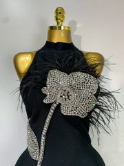 Close-up of diamond and feather floral embellishment on turtleneck sleeveless midi dress.