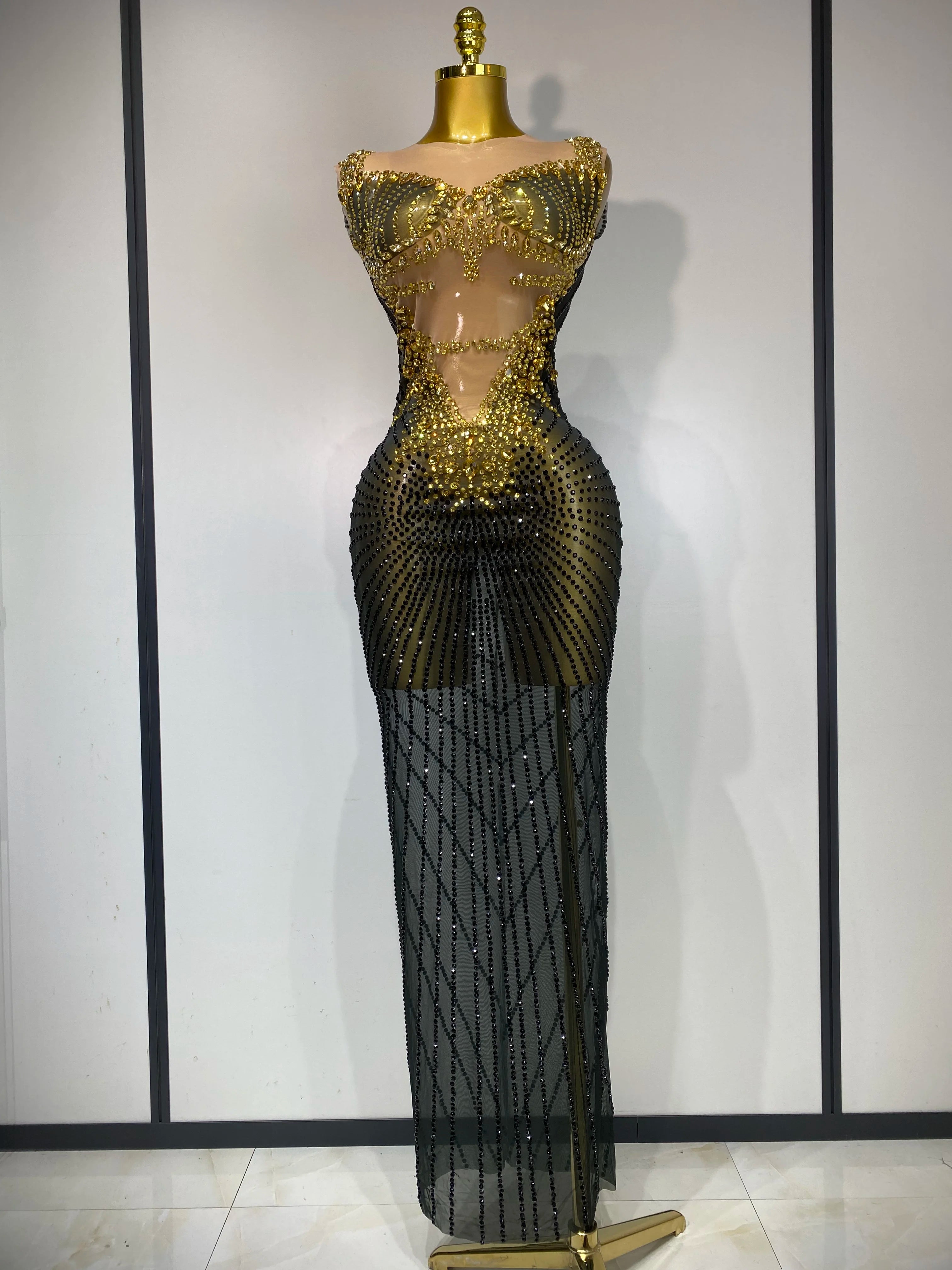 Gold and black beaded evening gown on a mannequin against a plain background