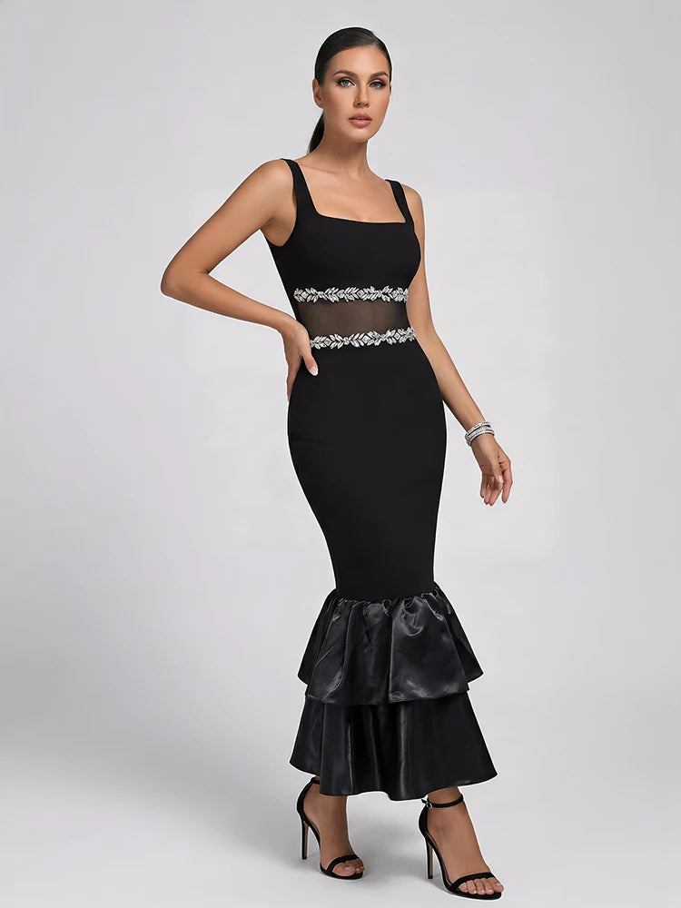 Model posing in a black pearl-embellished midi dress with satin ruffles.