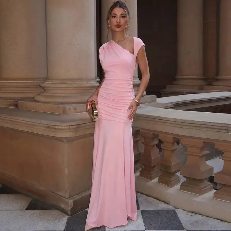 Model wearing a pink one-shoulder maxi dress with a clutch