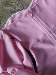 Close-up of a pink jacket with a zipper on a textured surface