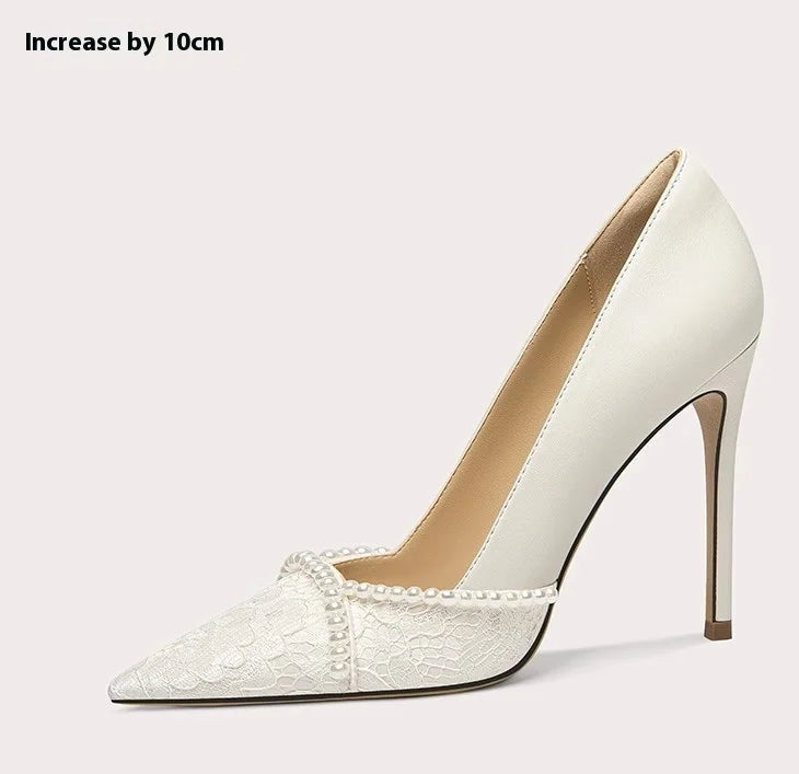 White high-heeled shoe with lace detail on a light gray background