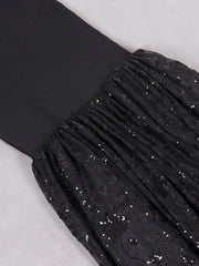 Black pleated fabric with sequin embellishments on a light gray background
