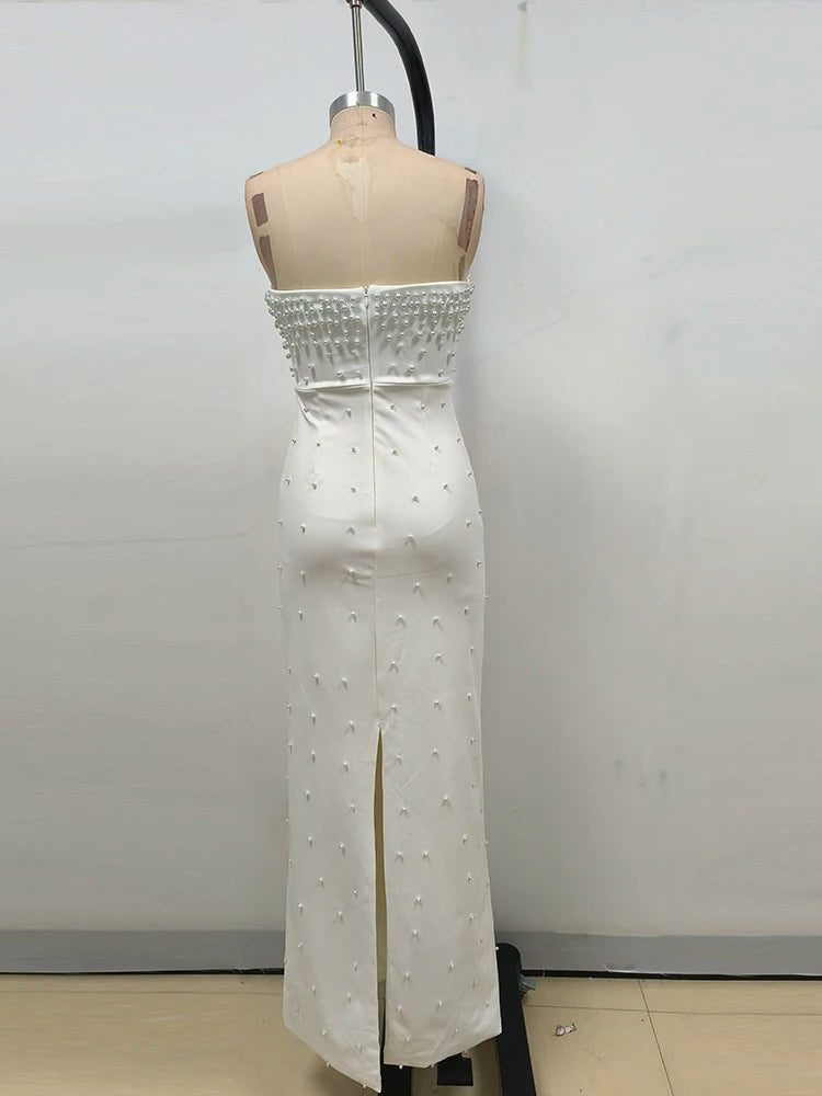 White strapless dress with pearl embellishments on a mannequin against a plain background