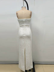 White strapless dress with pearl embellishments on a mannequin against a plain background