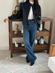 Black faux leather moto jacket with wide-leg jeans