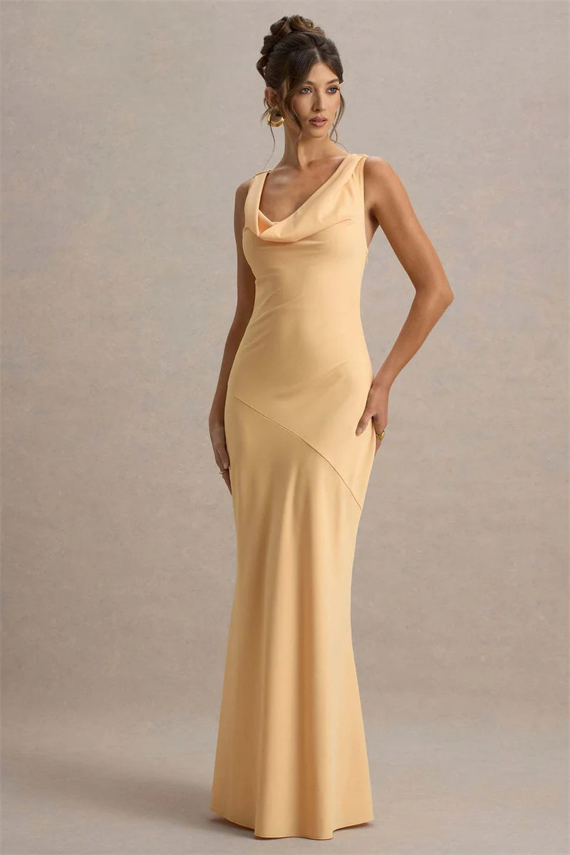 Woman wearing a long, sleeveless yellow dress against a neutral background
