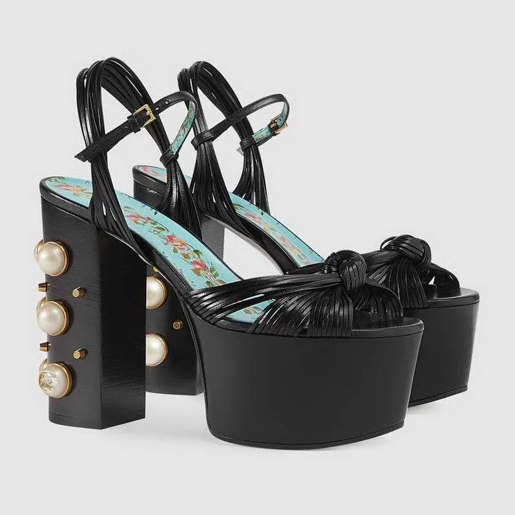 Black leather platform sandals with a chunky block heel and pearl detail.