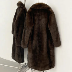 Brown fur coat on a hanger against a white wall