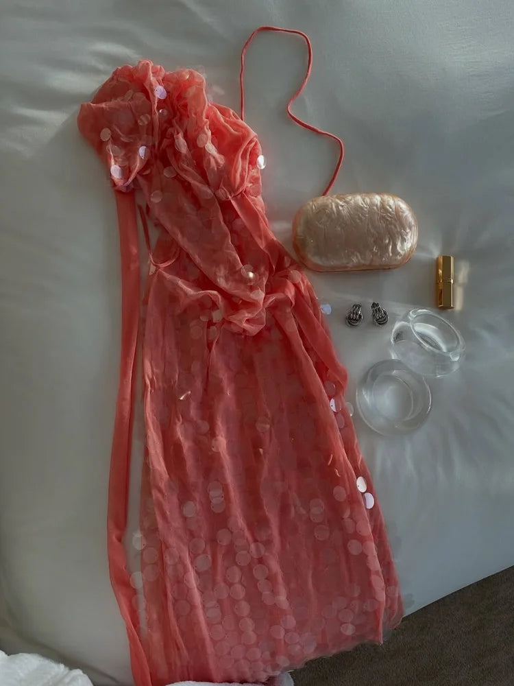 Pink dress with accessories on a white surface