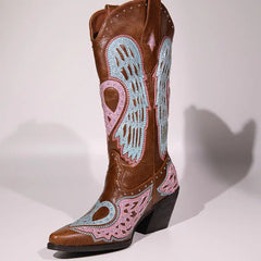 Brown cowboy boot with pink and blue heart designs on a white background