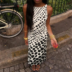 Woman in a polka dot dress standing on a sidewalk with a bicycle in the background