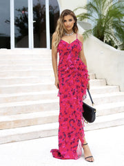 Woman in a pink floral dress standing on steps outdoors