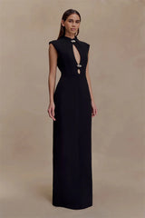 Woman wearing a black evening gown with a deep neckline on a beige background