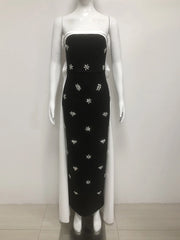Black dress with white floral patterns on a mannequin against a white background