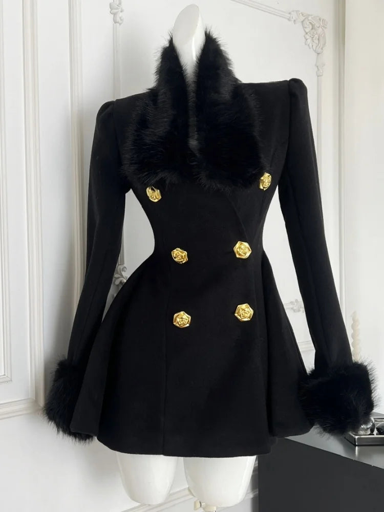 Black coat with fur collar and gold buttons on a mannequin against a white wall.
