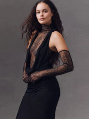Woman wearing a black lace dress against a gray background