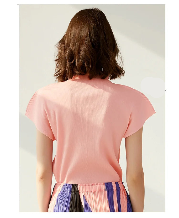 Person wearing a pink top with a plain background