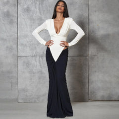 Woman wearing a white top and black skirt against a gray background