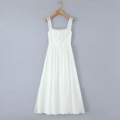 White dress on a wooden hanger against a gray background