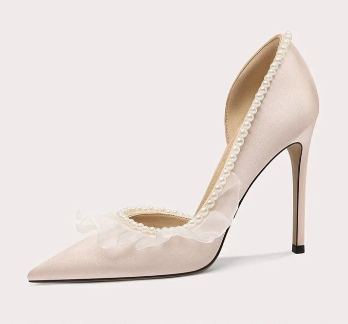 Beige high-heeled shoe with lace details on a light gray background