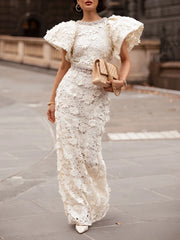 Close-up of the crystal embellishment on the neckline of a white lace gown.