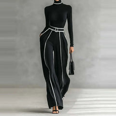 Black outfit with white trim on a neutral background