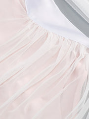 Close-up of a light pink tulle skirt with a white top underneath.
