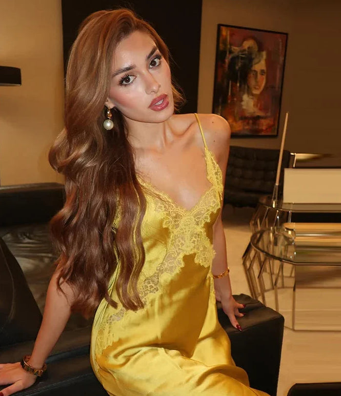 Woman in a yellow lace dress posing in an elegant room.