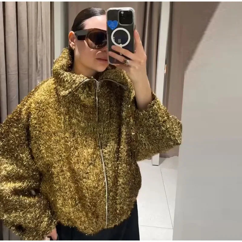 Person wearing a gold textured jacket taking a mirror selfie.