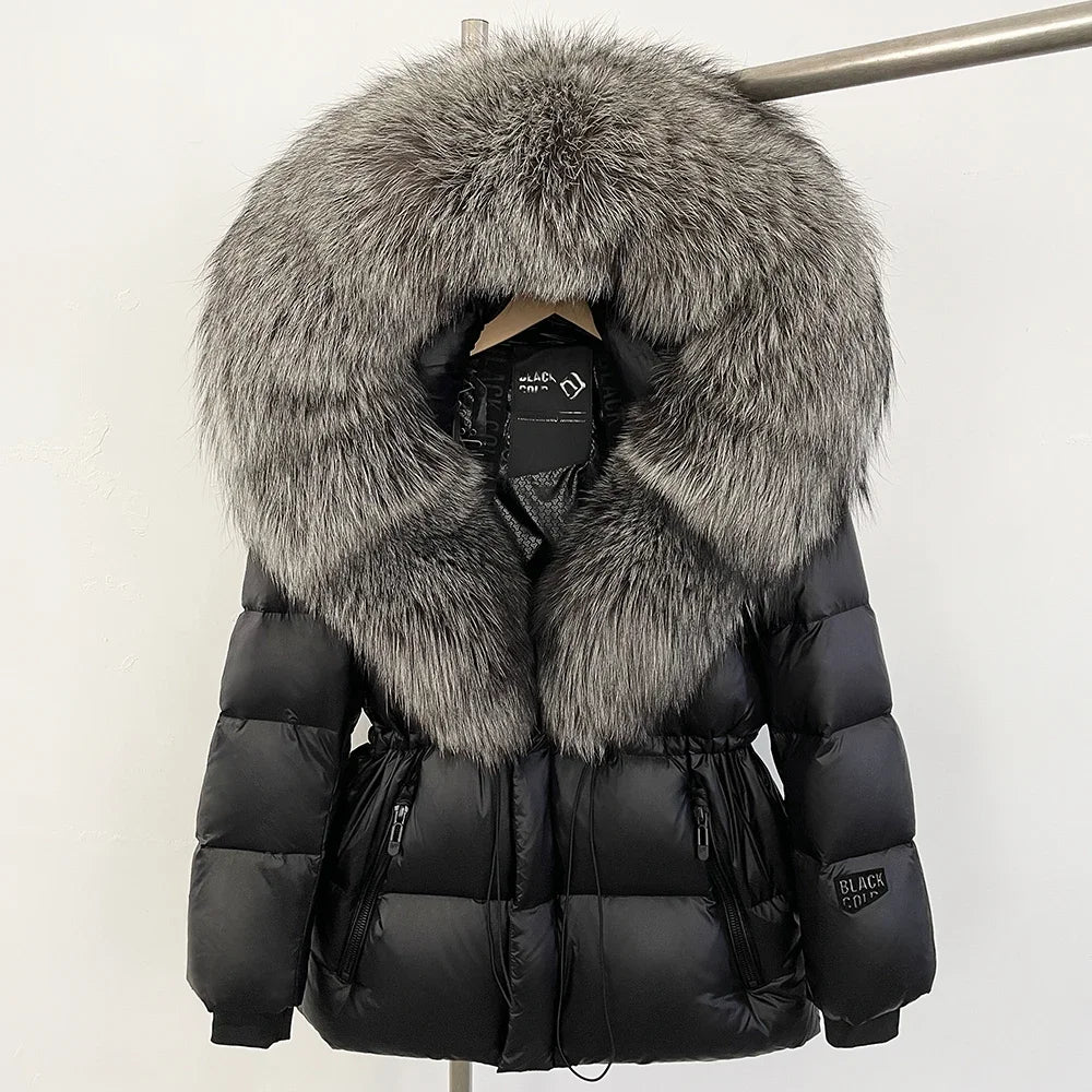 Black puffer jacket with large fur hood on a mannequin against a white background