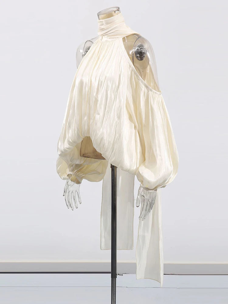Mannequin wearing a flowing white garment on a plain background