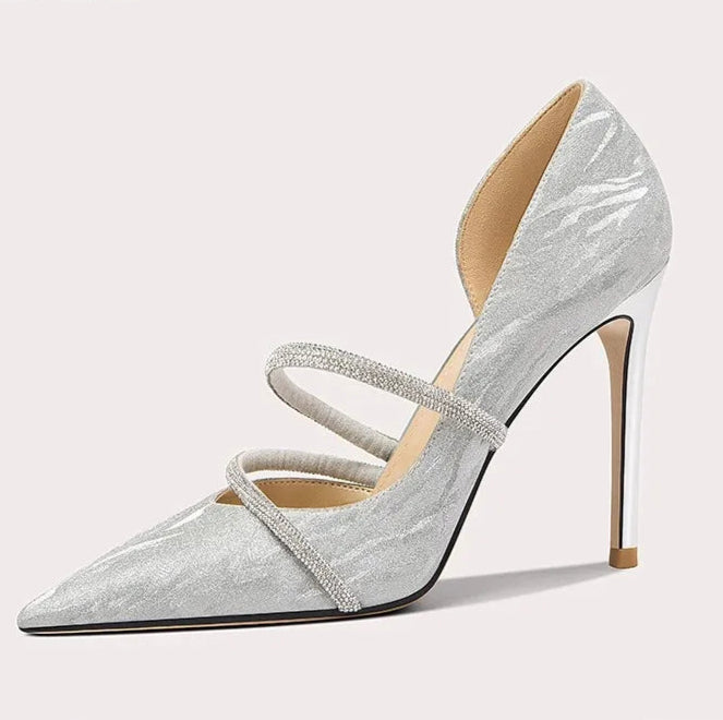 Silver high-heeled shoe with a strap on a light gray background