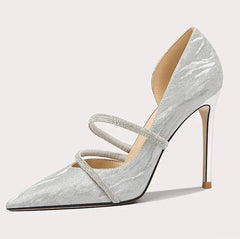 Silver high-heeled shoe with a strap on a light gray background