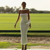 Woman wearing white strapless bodycon dress with mesh scarf outdoors