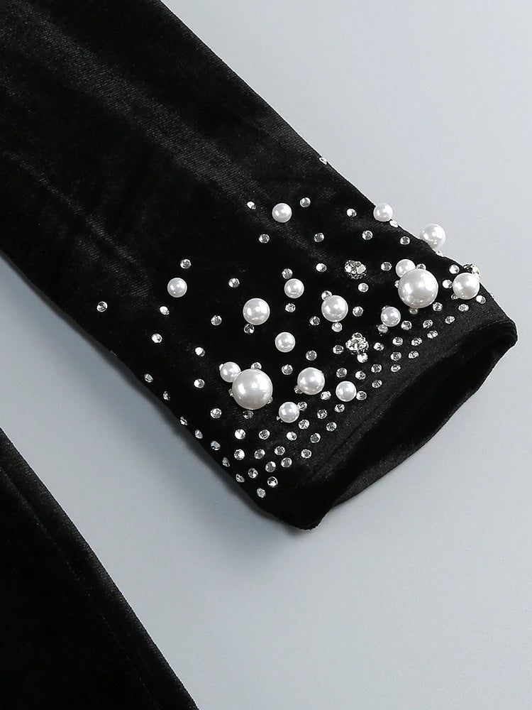 Black sleeve with pearl and crystal embellishments on a light gray background