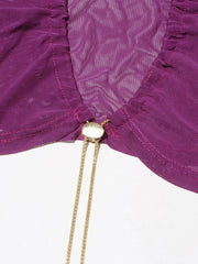 Close-up of a purple fabric with a gold chain and decorative element on a white background